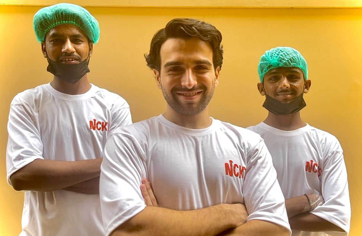 Aneeq, founder of NICK'S, with arms crossed, flanked by two team members in NICK'S t-shirts